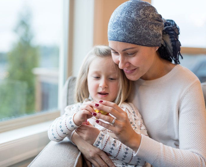 Woman holding a child in her arms playing with a toy