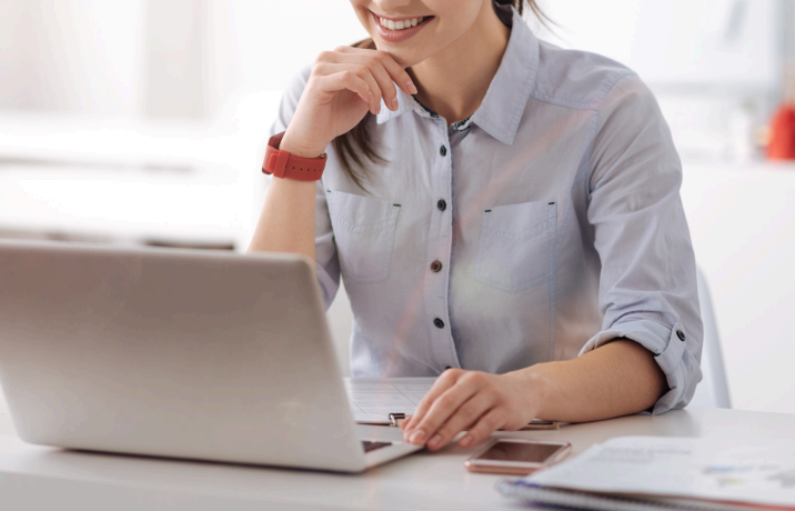 Smiling woman working on a laptop at a desk